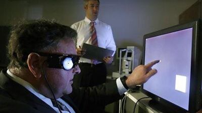 A man uses a touch screen monitor to test his Argus II eye implant at UCSF medical centre in San Francisco.