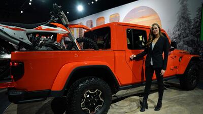 A product specialist stands next to a Jeep at the 2019 Detroit Auto Show. The industry event is cancelled this year due to surging number of the conronavirus cases in the US. AFP