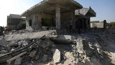Syrians check the damage in an area targeted by reported air strikes by pro-government forces in the town of Binnish in Idlib province on June 11, 2018. Omar haj Kadour / AFP