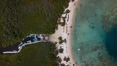 Boats park as people swim at Morrocoy National Park, Falcon state, Venezuela. AP