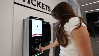 A passenger gets a ticket to ride on the Dubai train.