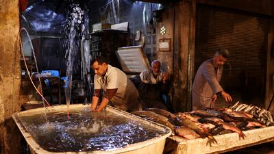 Iraqi vendors prepare their fish for sale at the market