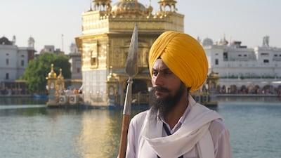 A Sikh volunteer armed with a spear stands in front of the Golden Temple, the holiest site in Sikhism, in the Indian city of Amritsar in Punjab state. Taniya Dutta for The National.