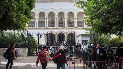 People walk in front of the Tunis Palace of Justice in Tunis. More than 40 people have been summoned to face trial over Tunisia's deadliest attack in a Mediterranean resort in 2015. The trial reopened on Tuesday in Tunis, more than three-and-a-half years after the attack on the Imperial Hotel in the beach resort of Sousse left 38 people dead, mostly British tourists. AP