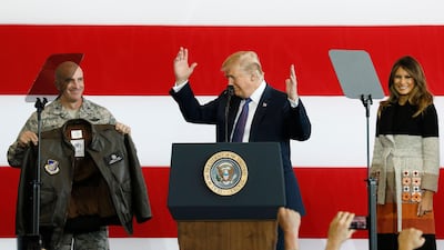 US president Donald Trump (C) receives a flight jacket from a service member as First Lady Melania Trump (R) looks on, during an address to US service persons at Yokota Air Base in Fussa, Tokyo Prefecture, Japan, on November 5, 2017. Kimimasa Mayama / EPA