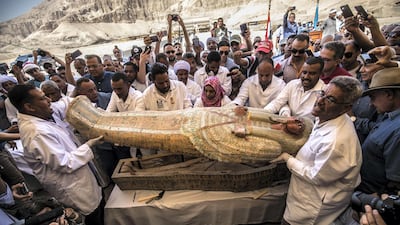 Egyptian archeologist open a wooden coffin belonging to a man in front Hatshepsut Temple at Valley of the Kings in Luxor. AFP