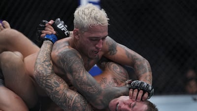 Charles Oliveira pins Dustin Poirier to the mat. Reuters