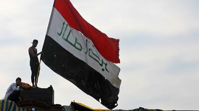 An Iraqi demonstrator waves a large national flag in the capital Baghdad's Tahrir Square, amid ongoing anti-government protests. AFP