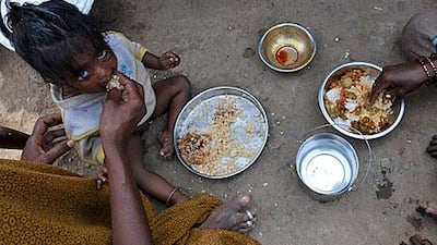 An Indian women feeds her child at the side of the road in Hyderabad. The new food subsidy bill is intended to help India's poorest get enough to eat, but some experts doubt whether it will provide for the most needy.