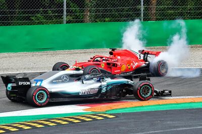 Mercedes-GP's Valtteri Bottas, in front, drives past Ferrari driver Sebastian Vettel's car after the latter crashed with Bottas' teammate Lewis Hamilton. AFP