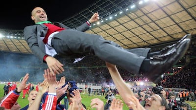 Bayern Munich head coach Pep Guardiola, top, is thrown into the air by his players after they beat Borussia Dortmund in the German Cup final. Kay Nietfeld / EPA / May 17, 2014