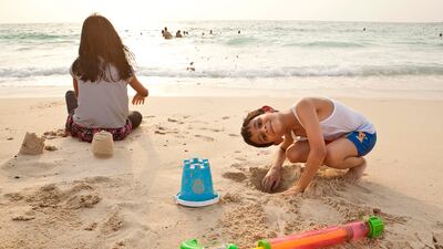 Children play on the beach in Deira, Dubai at the start of the 2021 summer holidays. Antonie Robertson / The National