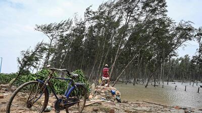 Residents collect debris from a damaged area near a beach after Cyclone Yaas hit India's east coast in the Bay of Bengal in Digha. AFP