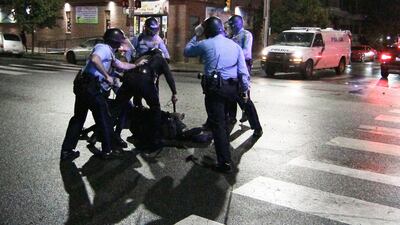 Police surround a man after chasing him down during a violent protest after police shot and killed a 27-year-old Black man. The Philadelphia Inquirer via AP