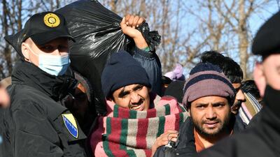 Migrants leave the camp after it was destroyed by a fire. AFP