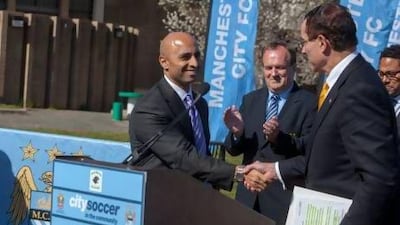 The UAE Ambassador to the US, Yousef Al Otaiba, shakes Washington DC mayor Vincent Gray's hand at the ground-breaking ceremony for the football pitch at Marie Reed Elementary school. Evelyn Hockstein / The National