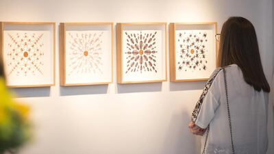 A lady takes in Hadil Moufti's Animal Mandalas at the Made in Tashkeel exhibition. Courtesy: Tashkeel