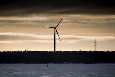 A man walks on the frozen Baltic Sea in front of a wind turbine. AFP