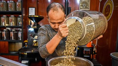 The owner selects arabica coffee beans for roasting at a coffee roastery in Banda Aceh, Indonesia. AFP
