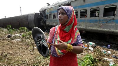 Tammanna Begum shows a shoe of her missing son, found near the wreckage of one of the train compartments. EPA