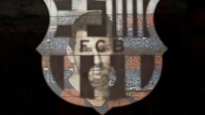 A picture of Lionel Messi is reflected in the Barcelona emblem outside the Camp Nou. Reuters