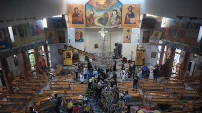 People and rescuers inspect the damage after the attack. AFP