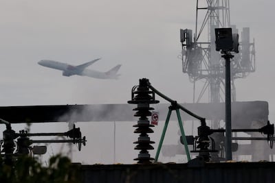 A plane takes off as smoke rises from an electrical substation a day after it caught fire and wiped out power at Heathrow Airport. Reuters