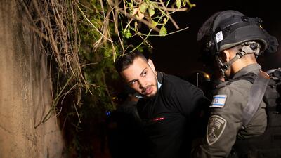 A Palestinian man is detained by Israeli police at a protest against the eviction of families from their homes in Sheikh Jarrah, East Jerusalem. Protesters and Jewish settlers hurled rocks and chairs at one another. AP