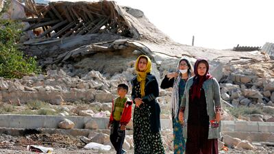 Iranians walk past the rubble of buildings in Kouik village two days after a 7.3-magnitude earthquake struck Iran's western Kermanshah province. Atta Kenare / AFP Photo
