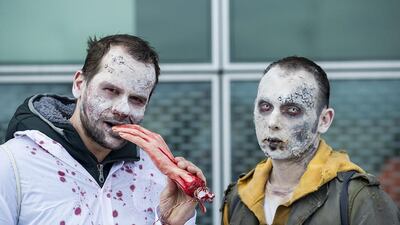 Two men dressed up as Zombies pose for a picture. Marco Secchi / Getty Images