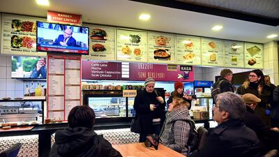 Supporters of Turkish leading businessman and rights defender Osman Kavala watch television news after Istanbul prosecutors issued a new arrest warrant for Kavala, as part of a separate probe following his acquittal earlier in the day. AFP