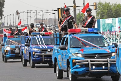 A convoy in Baghdad of Iraqi police vehicles decorated with national flags marks the withdrawal of US troops from Iraq. EPA