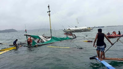 Rescuers check the remains of a ferry boat after it capsized. Philippine Red Cross via AP