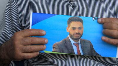 Mohammed Allan, pictured in this poster held by his father Naser Al Deen Allan. Israel reinstated the detention without trial of the Palestinian detainee. Jaafar Ashtiyeh / AFP Photo files