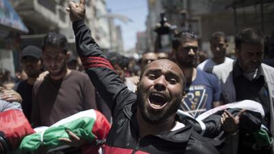 A Palestinian man chants angry slogans during the funeral of three children who were killed in a fire caused by a candle in the Shati refugee camp in Gaza City. Khalil Hamra / AP Photo
