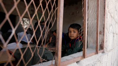 A Yemeni pupil peers out of the window of a classroom at a public school in Sanaa. About one in six schools have been destroyed during fighting in the country. EPA