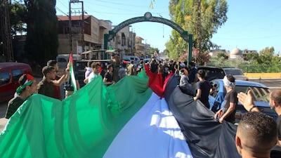Pro-Palestinian protesters march with a large flag during a rally in the southern Lebanese village of Adaisseh, marking the Nakba and denouncing Israeli violence in Gaza and Jerusalem. AFP