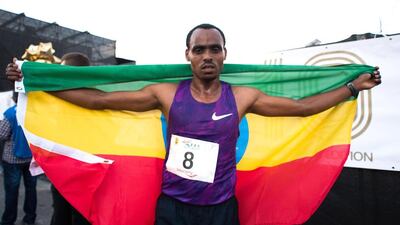 Legese celebrates his win with the Ethiopian flag draped on his shoulders.