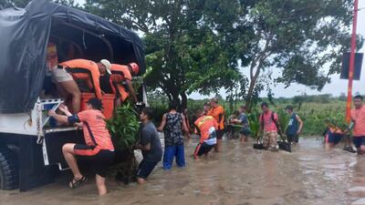Rescuers help residents move to safer ground in Tuguegarao, the Philippines on Tuesday. AP