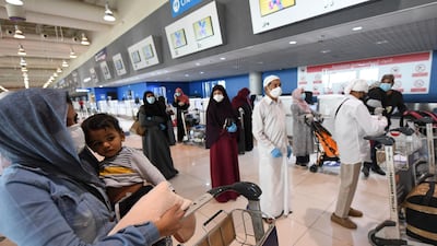 An Indian woman carries a child as she waits at the Dubai International Airport before leaving the country on a flight home on May 7. Karim Sahib / AFP