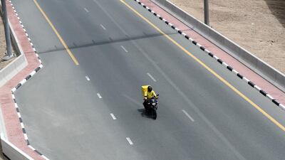 Corona. A car scooter drives off Sheikh Zayed Road during the 24hr lockdown due to Covid-19. Dubai. Chris Whiteoak / The National