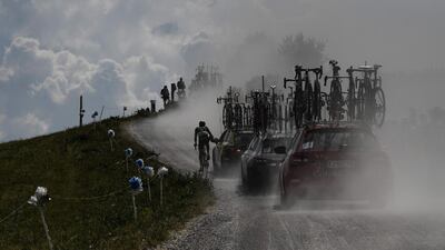 France's Fabien Grellier rides by his team's manager car in the ascent of Plateau des Glieres during the 10th stage of the Tour de France between Annecy and Le Grand-Bornand. Jeff Pachoud / AFP