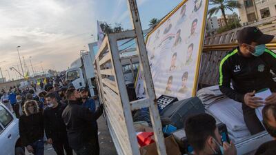 Pro-Iranian militiamen and their supporters load trucks with items from dismantled tents, in front of the US embassy, in Baghdad, Iraq. AP Photo