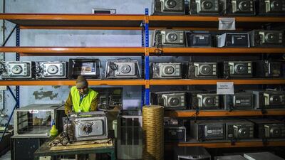 An employee repairs an LG Electronics microwave oven in the home appliances section at the refurbishment facility of GreenDust. Prashanth Vishwanathan / Bloomberg