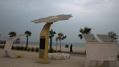 People walk near a solar-powered smart palm tree in Dubai. EPA