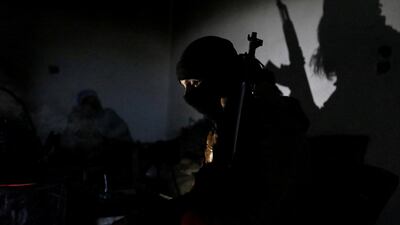 A Turkish-backed Syrian rebel warms himself around a fire in the town of Tadef in Aleppo Governorate, Syria. REUTERS