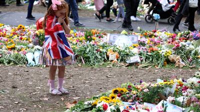 Ann Doran, 6, looks at floral tributes left in Green Park. Reuters