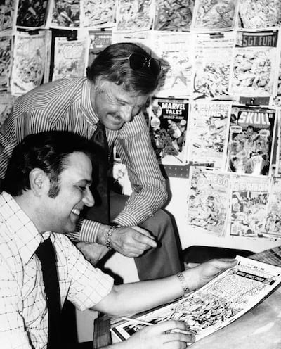 Stan Lee, standing, discusses a 'Spider-Man' comic book cover with artist John Romita at Marvel headquarters in New York in the mid-Seventies. AP