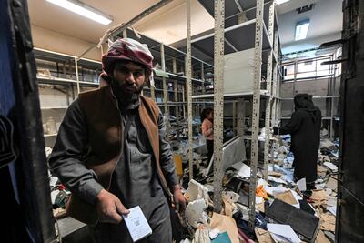 People search through scattered documents at the Palestine Branch in hopes of finding out the fate of missing relatives. AFP