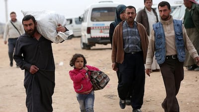 Syrians carry belongings at a bus station. After working for 10 days straight in a regime-held neighbourhood, Abu Asaad, 45, waits for the bus at a station in the New Aleppo district to go home to Shaar, a rebel area just five kilometres away.